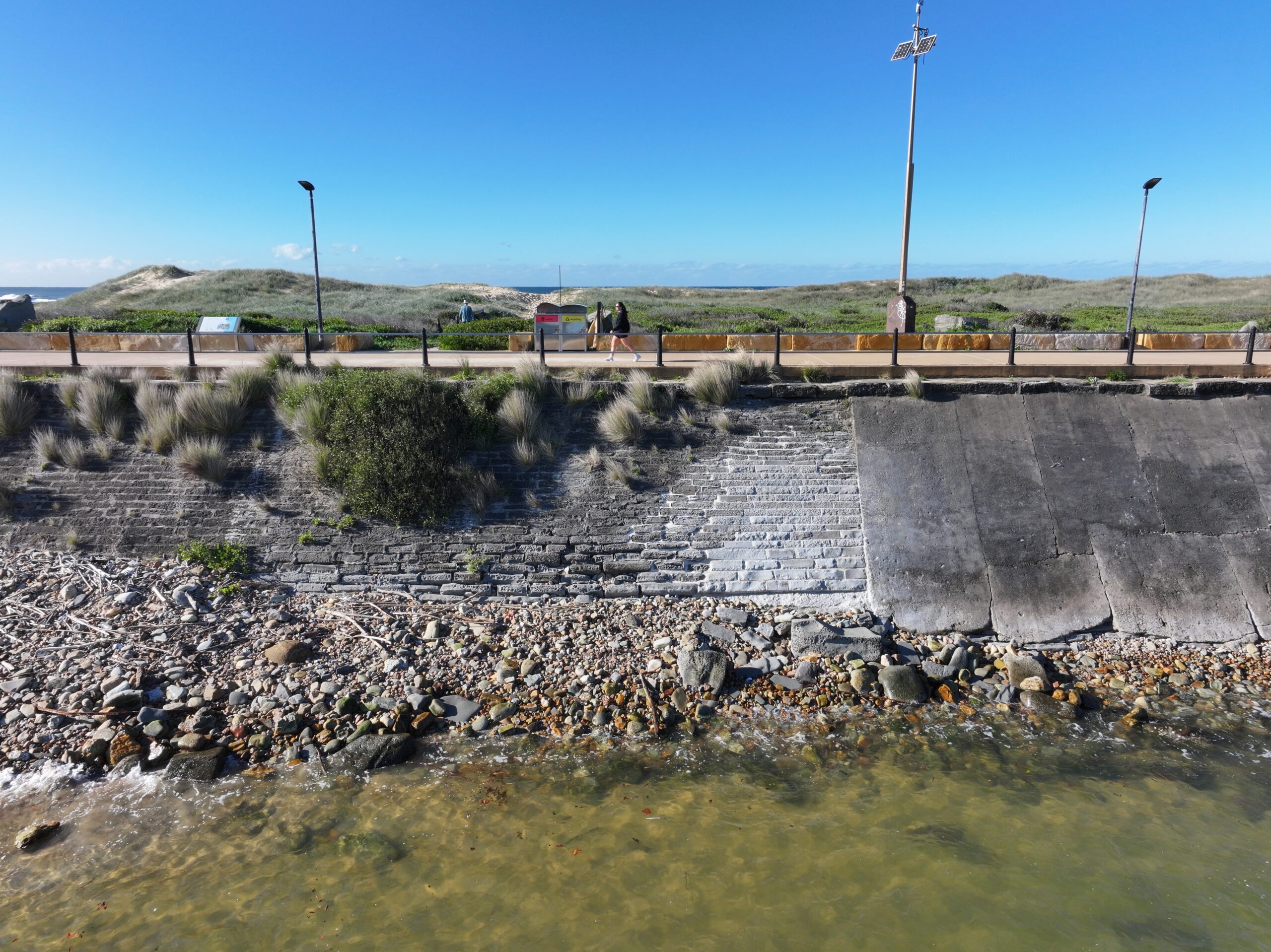 pedestrian-walk-past-a-restored-section-of-the-seawall-credit-eje-architects